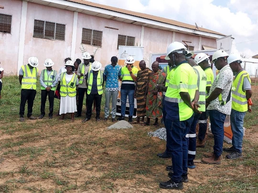 X-Mell crews in PPE joined by client representatives and traditional leaders at a project groundbreaking ceremony, AngloGold Ashanti banners behind